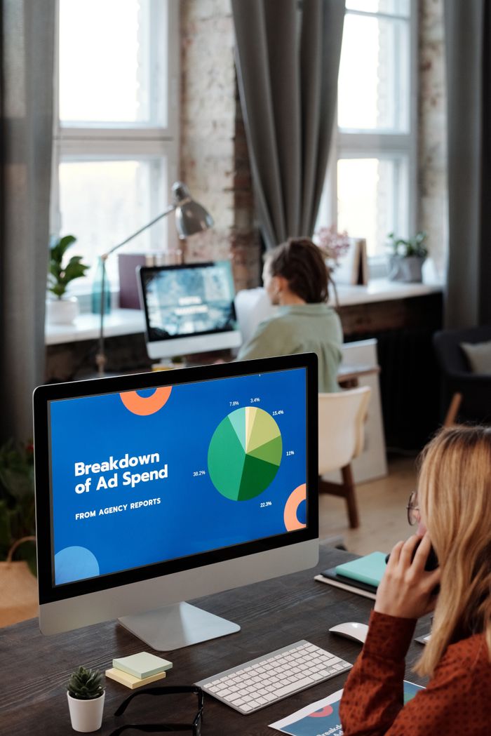 Un bureau lumineux avec des ordinateurs affichant des données, illustrant la productivité dans un espace de travail.
