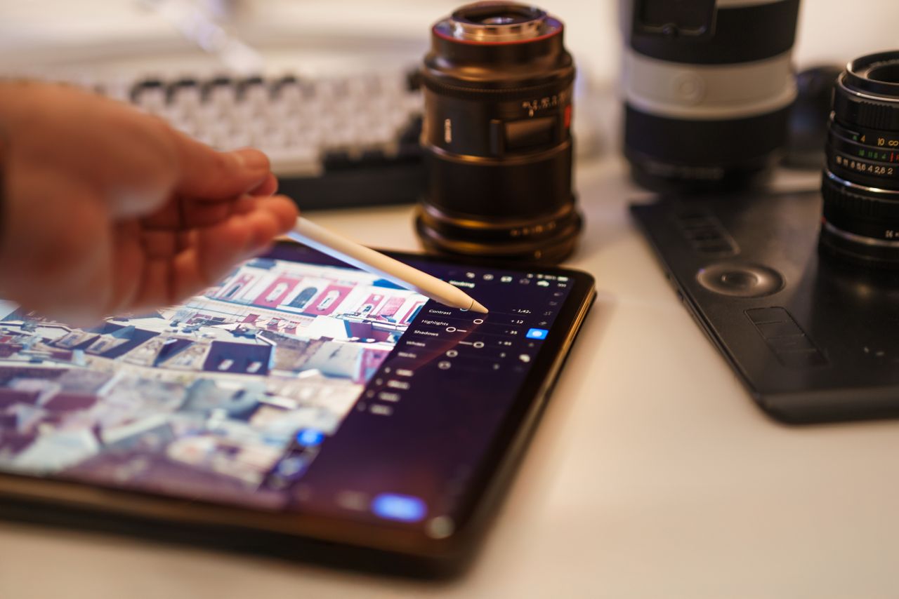 Une vue détaillée d’un poste professionnel de retouche photo avec tablette et objectifs.